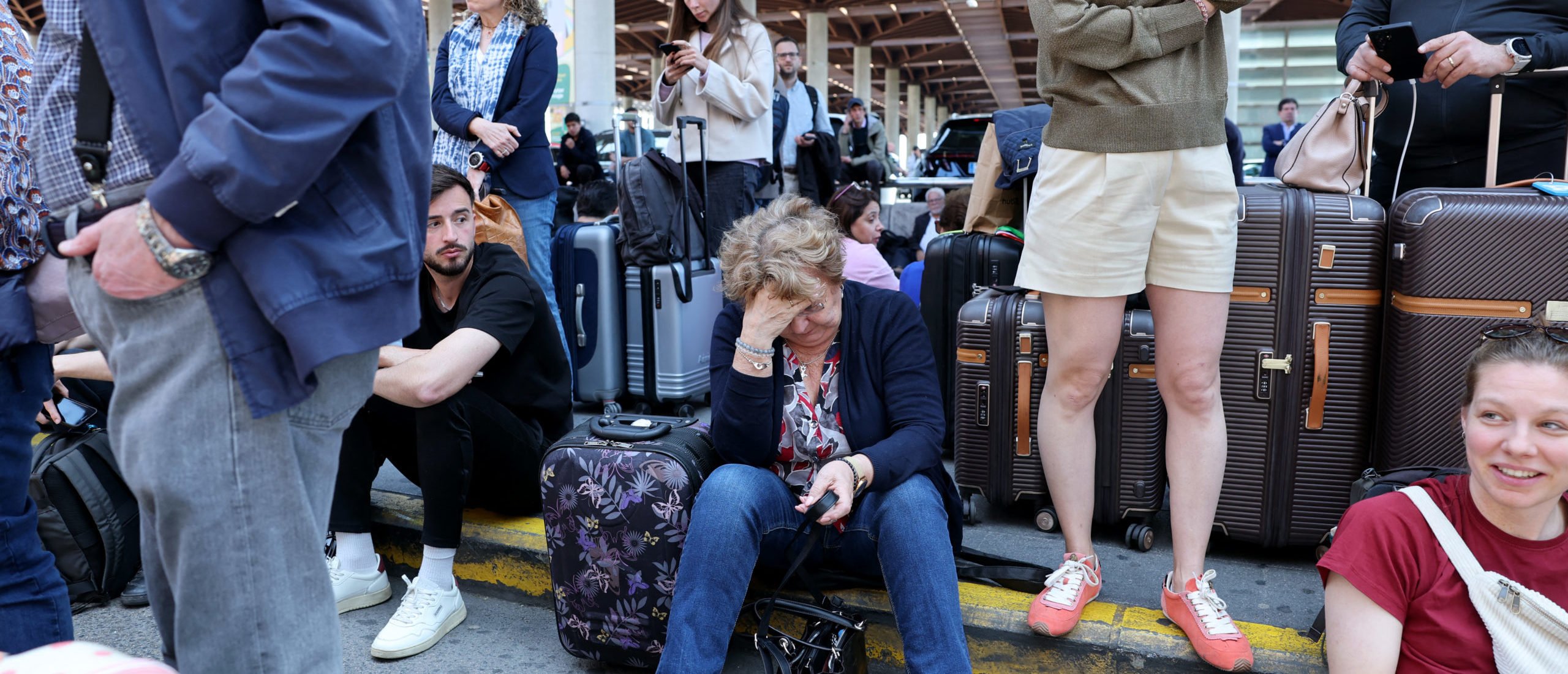 People wait outside the Atocha train station in Madrid after its closure as a massive power outage hits Spain on April 28, 2025. (Photo by THOMAS COEX/AFP via Getty Images)