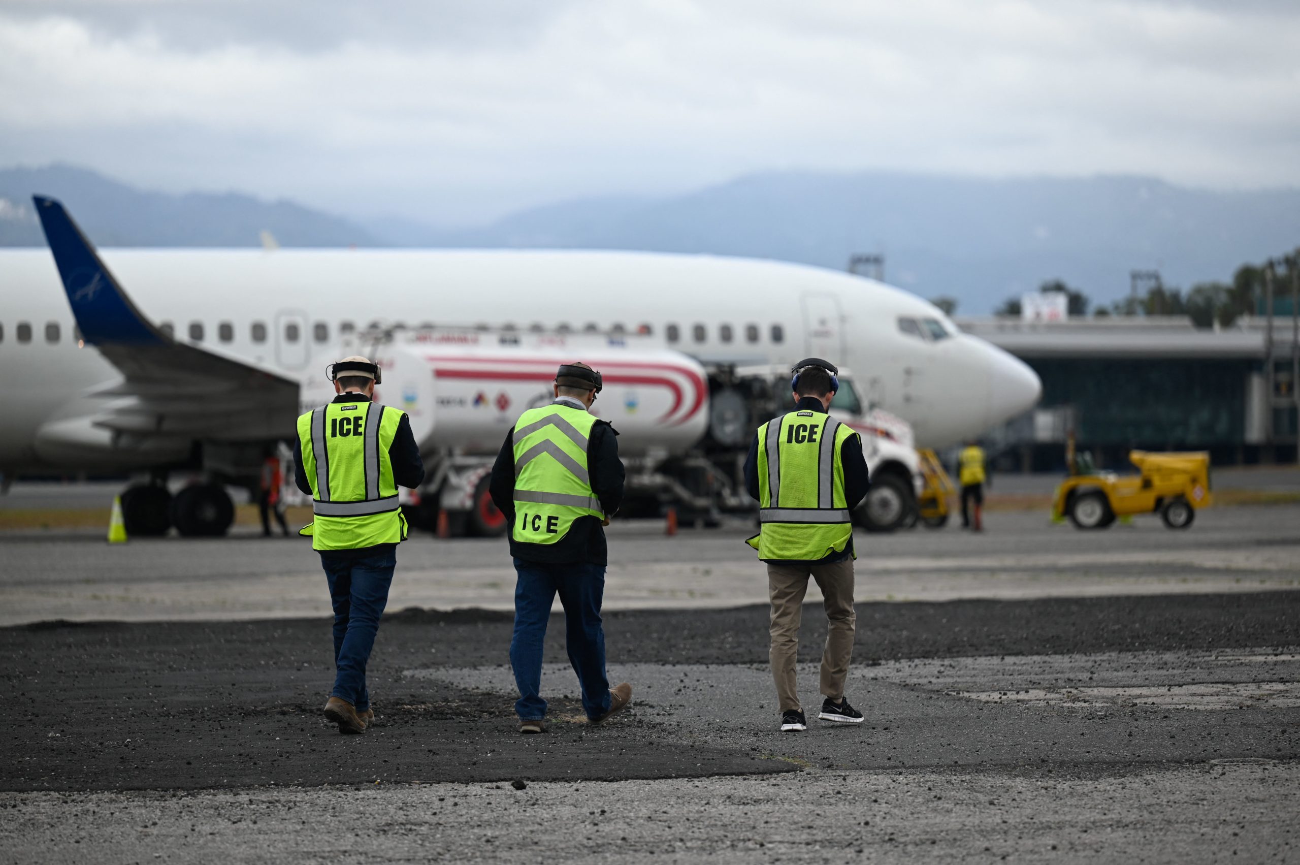 ICE agents prepare for the arrival of Guatemalan migrants deported from the United States at the Air Force Base in Guatemala City on January 27, 2023. (Photo by JOHAN ORDONEZ/AFP via Getty Images)