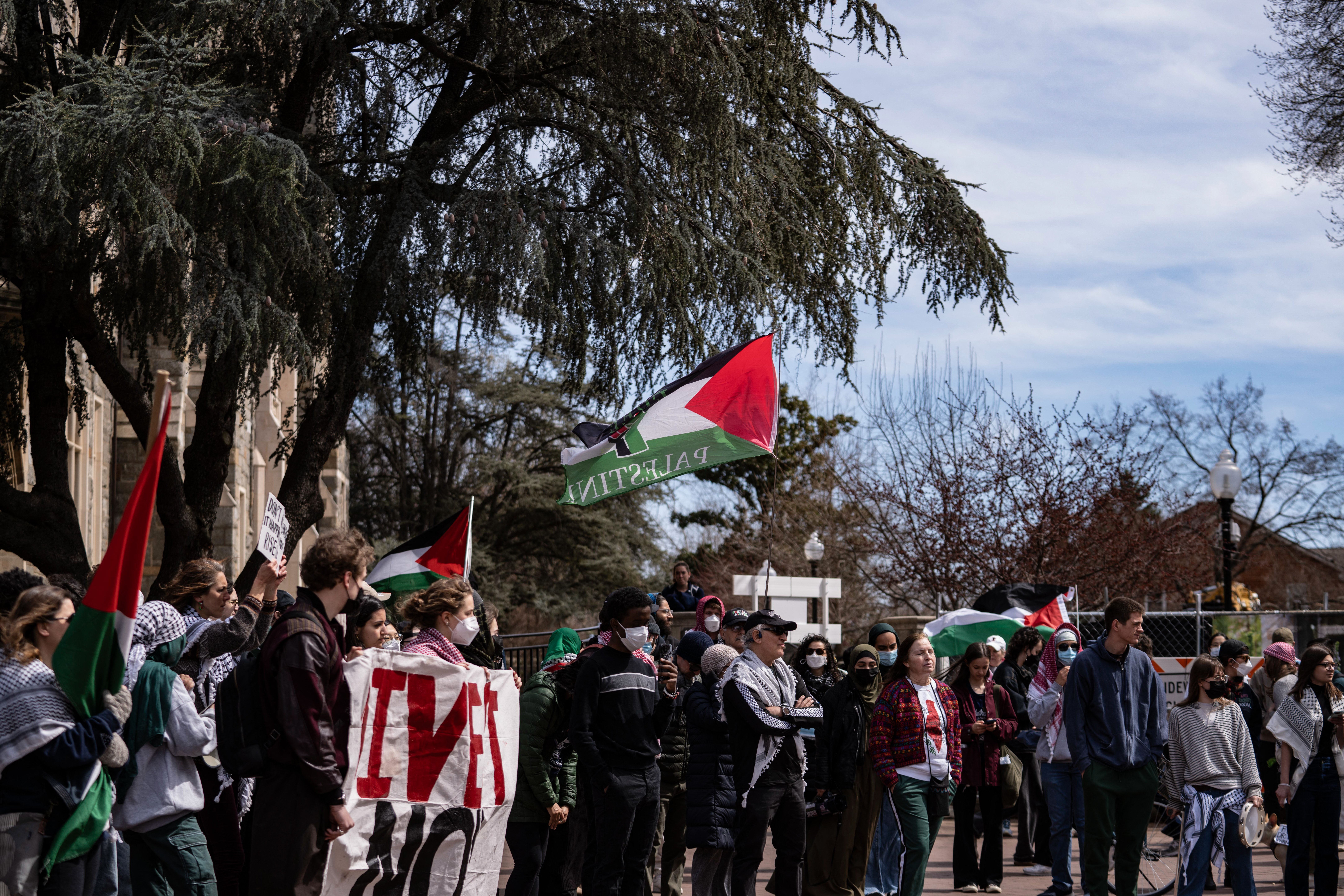 A protester waves a Palestinian flag during a protest against ICE, MPD, and other law enforcement agencies on college campuses in Washington, D.C., on March 23, 2025. The demonstration, organized by Georgetown University students and community leaders, also demanded the release of a Georgetown scholar facing deportation by the Department of Homeland Security. (Photo by ANDREW THOMAS/Middle Eeast Images/AFP via Getty Images)