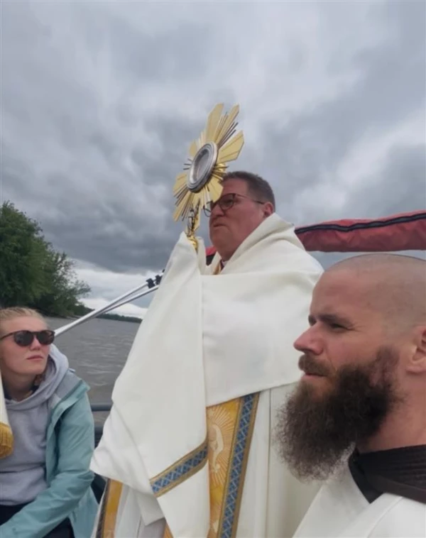 Father Michael Herlihey with Bishop Louis Tylka of Peoria, Illinois, and pilgrim Frances Webber cross the Mississippi River on May 21, 2025, in a fishing boat from the Diocese of Peoria into the Diocese of Davenport, Iowa, along the route of the 2025 Eucharistic Pilgrimage. Credit: Photo courtesy of Father Michael Herlihey