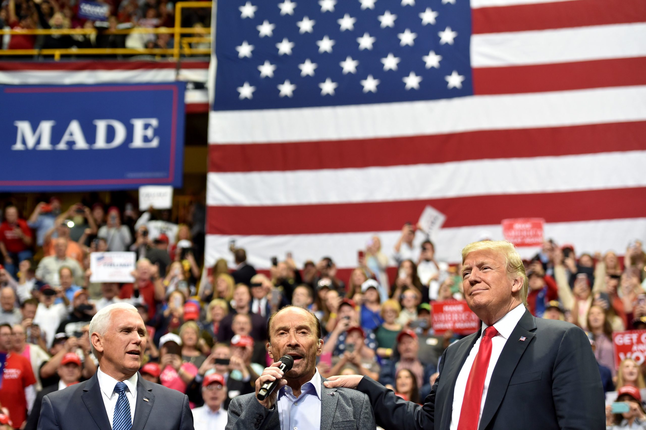 Singer Lee Greenwood (C) performs alongside US President Donald Trump and US Vice President Mike Pence during a