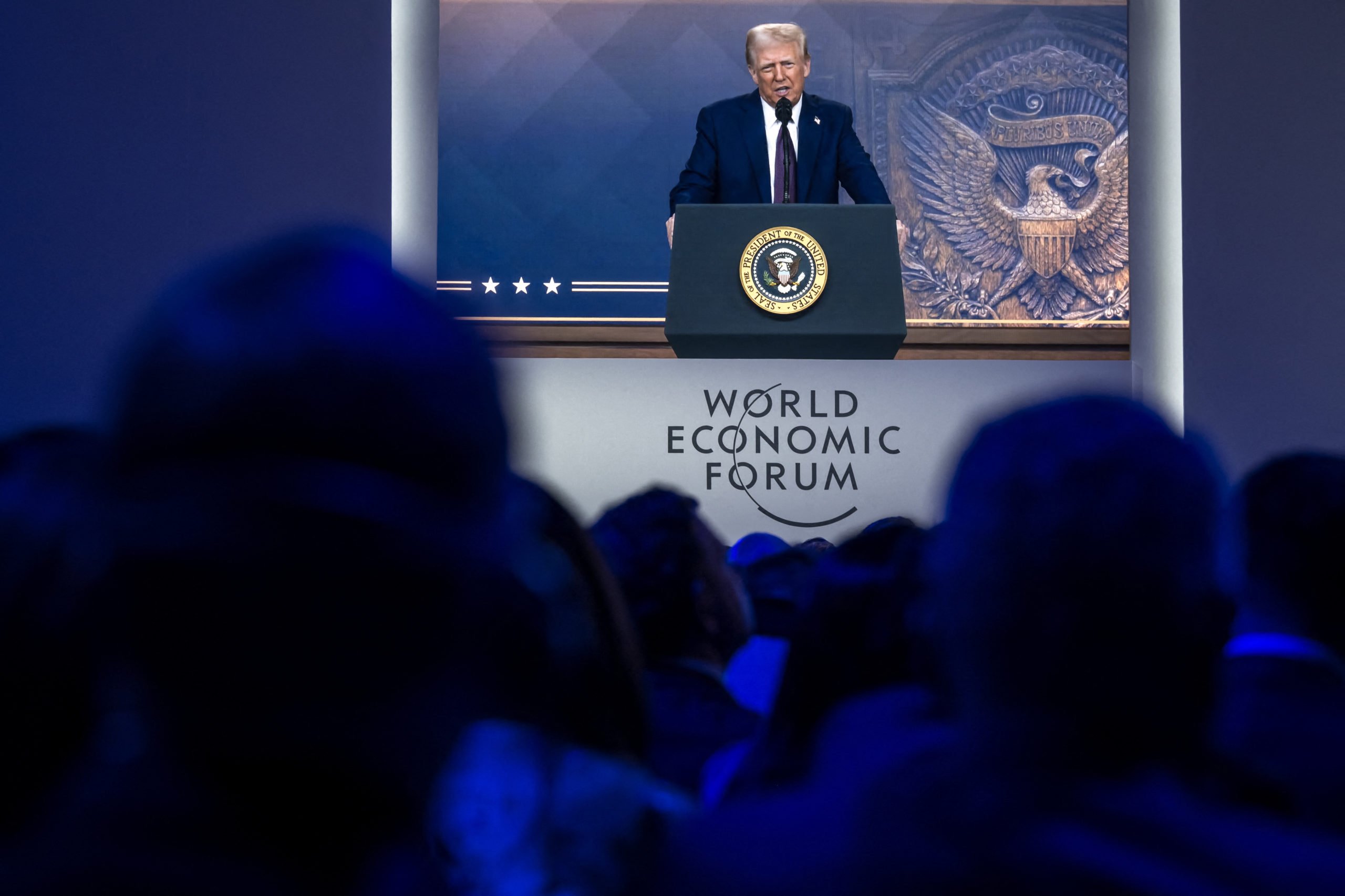 US President Donald Trump is seen on a large screen during his address by video conference at the World Economic Forum (WEF) annual meeting in Davos on January 23, 2025. (Photo by FABRICE COFFRINI/AFP via Getty Images)