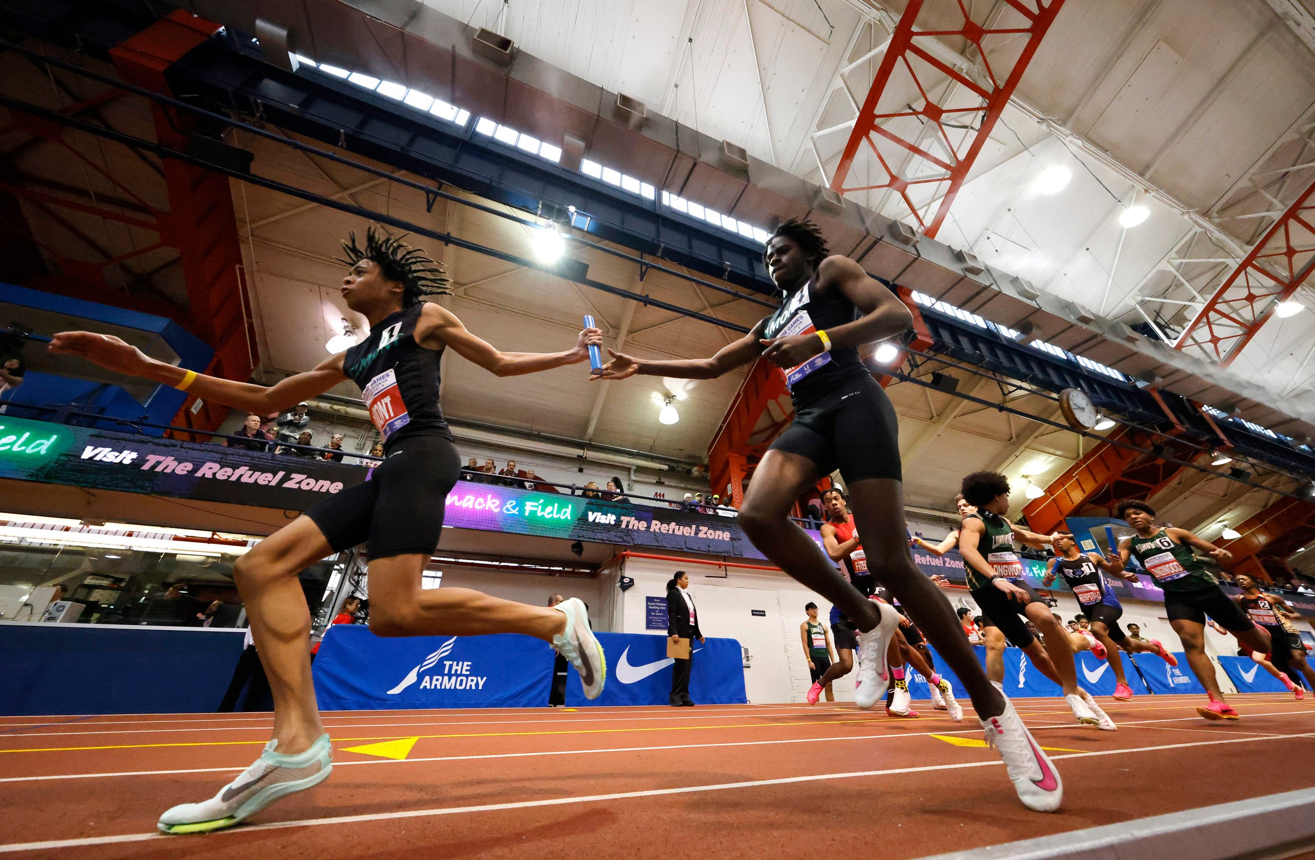 NEW YORK, NEW YORK - FEBRUARY 11: Aidan Peterkin hands off to Isaiah Davis of Elmont High School during the 116th Millrose Games at The Armory Track on February 11, 2024 in New York City. (Photo by Al Bello/Getty Images)