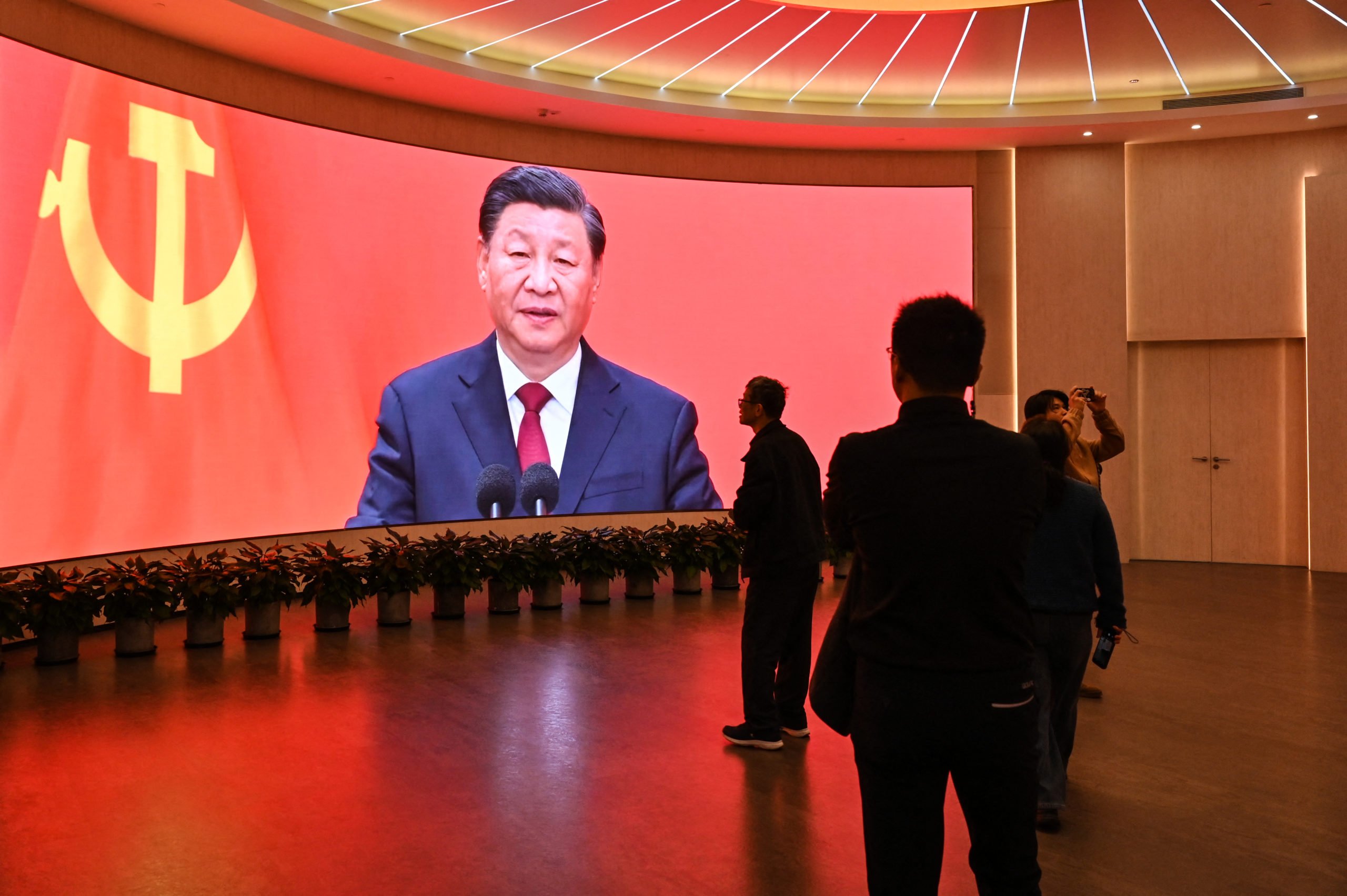 TOPSHOT - A screen shows images of China's President Xi Jinping as people visit the Museum of the First National Congress of the Chinese Communist Party in Shanghai on February 27, 2025, ahead of the opening of the annual session of the National People's Congress on March. (Photo by HECTOR RETAMAL/AFP via Getty Images)