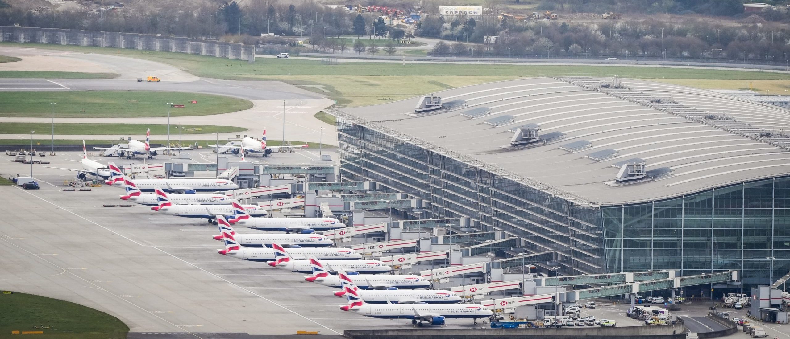 An aerial photograph taken on March 21, 2025 shows planes parked on the tarmac of Heathrow Airport following its closure after a fire broke out at a substation supplying power of the airport, in Hayes, west London. Britain's Heathrow airport, Europe's busiest, was shut down early on March 21 for 24 hours after a major fire at an electricity substation cut power to the sprawling facility west of London, officials said. (Photo by STR/AFP via Getty Images)