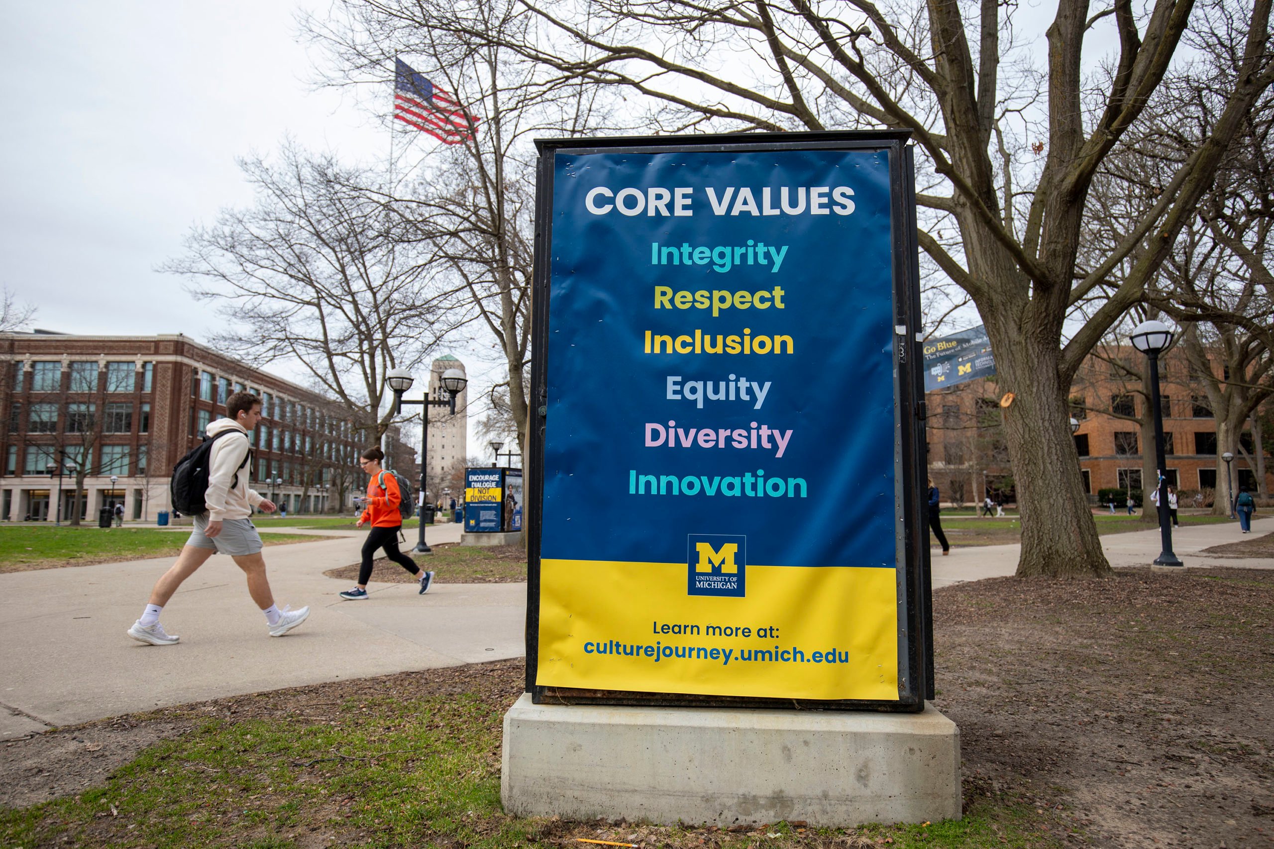 University of Michigan students walk on the UM campus next to signage displaying the University's "Core Values" on April 3, 2025. (Photo by Bill Pugliano/Getty Images)