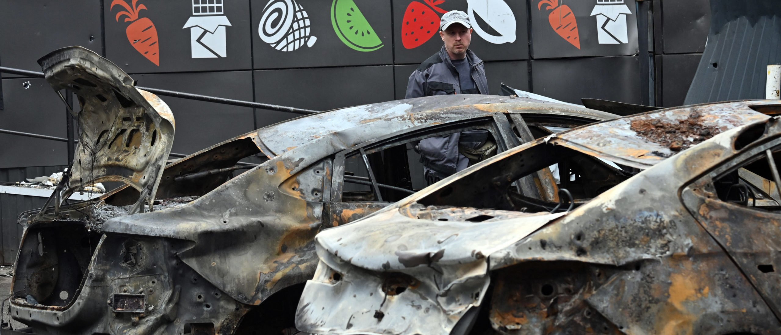 A man examine burned cars parked outside a mall following a night-time drone attack on Kyiv, on May 4, 2025 amid the Russian invasion of Ukraine. (Photo by SERGEI SUPINSKY/AFP via Getty Images)