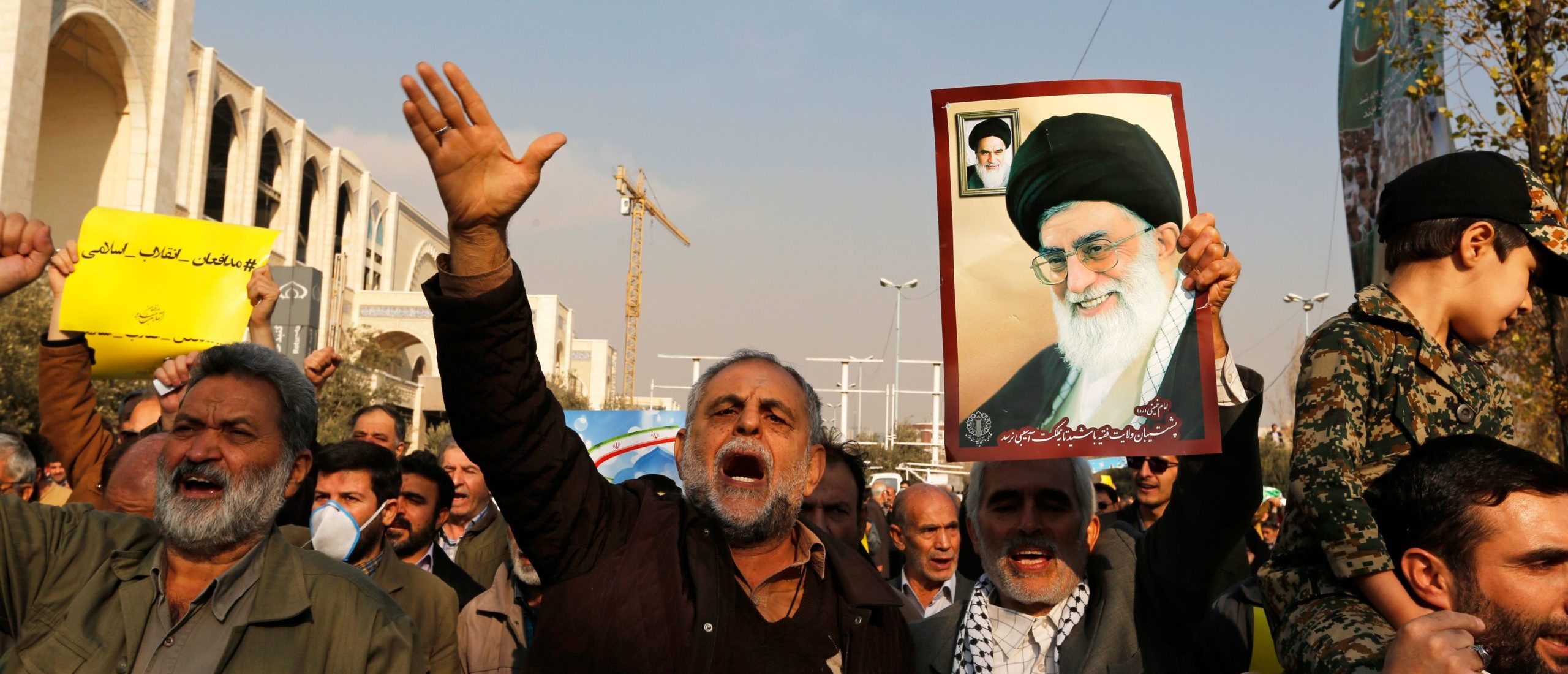 Pro-government demonstrators hold a poster of Iran's supreme leader, Ayatollah Ali Khamenei (R) and Iran's founder of Islamic Republic, Ayatollah Ruhollah Khomeini and shout slogans during a march following the weekly Muslim Friday prayers in Tehran on January 5, 2018. New pro-regime protests were held in Iran, in reaction to the protests against the government and the cost of living. (ATTA KENARE/AFP via Getty Images)