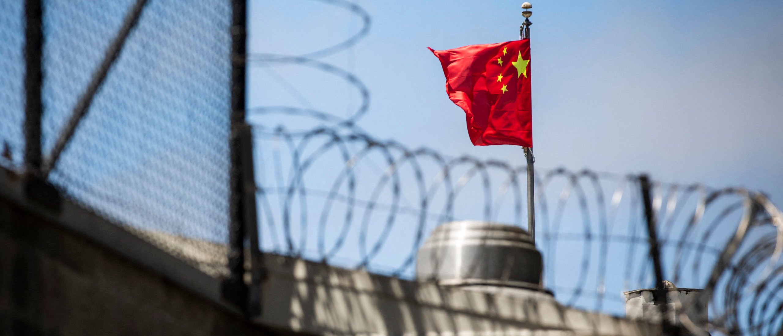 The flag of the People's Republic of China flies behind barbed wire at the Consulate General of the People's Republic of China in San Francisco, California on July 23, 2020. The US Justice Department announced July 23, 2020 the indictments of four Chinese researchers it said lied about their ties to the People's Liberation Army, with one escaping arrest by taking refuge in the country's San Francisco consulate. (Photo by PHILIP PACHECO/AFP via Getty Images)