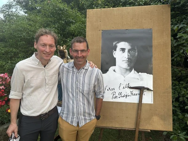 Brothers Vincent (left) and Cedric Ebiner pose before a photo of Pier Giorgio Frassati after traveling from Switzerland to attend the celebrations in Pollone, Italy, Thursday, July 3, 2025. Credit: Courtney Mares/CNA