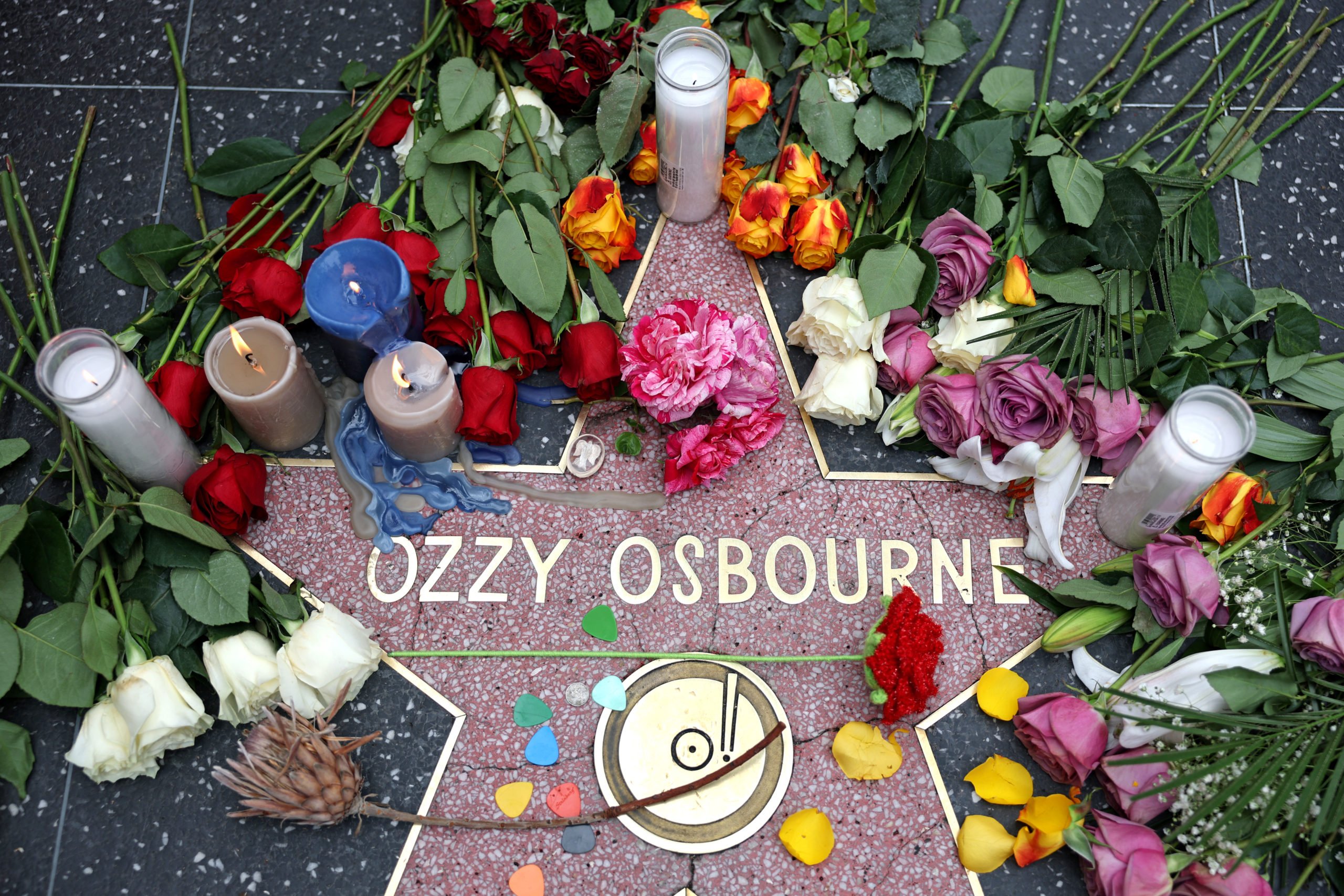 Flowers are left at a makeshift memorial at Ozzy Osbourne's Star on the Hollywood Walk of Fame on July 22, 2025, in Los Angeles. Osbourne, the legendary frontman of heavy metal group Black Sabbath, died on Tuesday at the age of 76, his family announced in a statement. "He was with his family and surrounded by love. We ask everyone to respect our family privacy at this time," the statement said. (Photo by Patrick T. Fallon / AFP) (Photo by PATRICK T. FALLON/AFP via Getty Images)