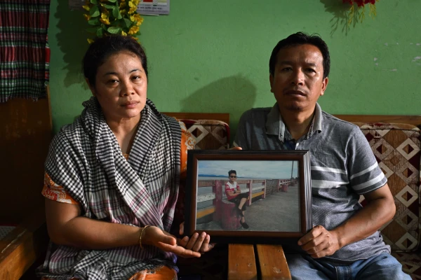 The parents of Ukya Chhaing Marma, a 14-year-old who died after a Bangladesh Air Force training jet crashed into his school on July 21, hold his photo at the family's house in Bandarban, Bangladesh, July 26, 2025. Credit: Piyas Biswas