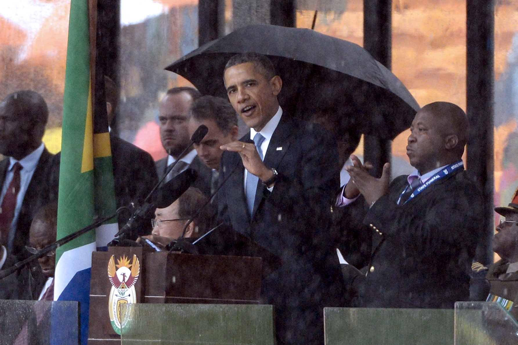 A sign language interpreter (R) gestures as US President Barack Obama delivers a speech during the memorial service for late South African President Nelson Mandela at Soccer City Stadium in Johannesburg on December 10, 2013. Mandela, the revered icon of the anti-apartheid struggle in South Africa and one of the towering political figures of the 20th century, died in Johannesburg on December 5 at age 95. Mandela, who was elected South Africa's first black president after spending nearly three decades in prison, had been receiving treatment for a lung infection at his Johannesburg home since September, after three months in hospital in a critical state. (Photo by PEDRO UGARTE/AFP via Getty Images)