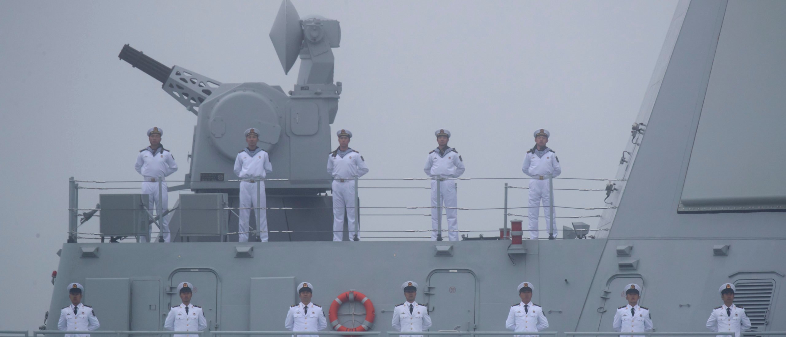 Sailors stand on the deck of the new type 055 guide missile destroyer Nanchang of the Chinese People's Liberation Army (PLA) Navy as it participates in a naval parade to commemorate the 70th anniversary of the founding of China's PLA Navy in the sea near Qingdao, in eastern China's Shandong province on April 23, 2019. - China celebrated the 70th anniversary of its navy by showing off its growing fleet in a sea parade featuring a brand new guided-missile destroyer. (Photo by Mark Schiefelbein / POOL / AFP via Getty Images)