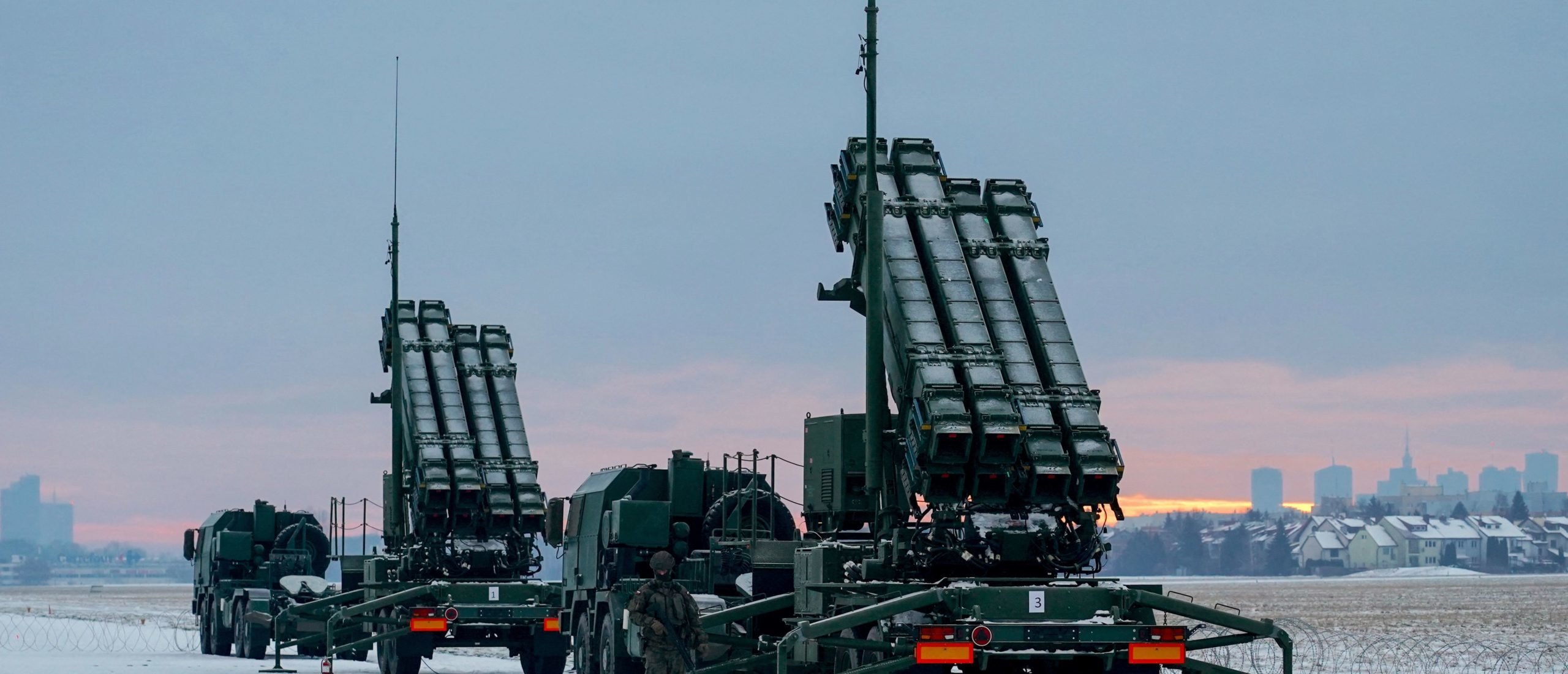 A soldier stands next to PATRIOT (Phased Array Tracking Radar to Intercept on Target) surface-to-air missile systems ahead a military exercise at Warsaw Babice Airport, Poland on February 7, 2023. - Patriot missile systems purchased by Poland last year have been redeployed to the Polish captital for military exercises. (Photo by JANEK SKARZYNSKI/AFP via Getty Images)