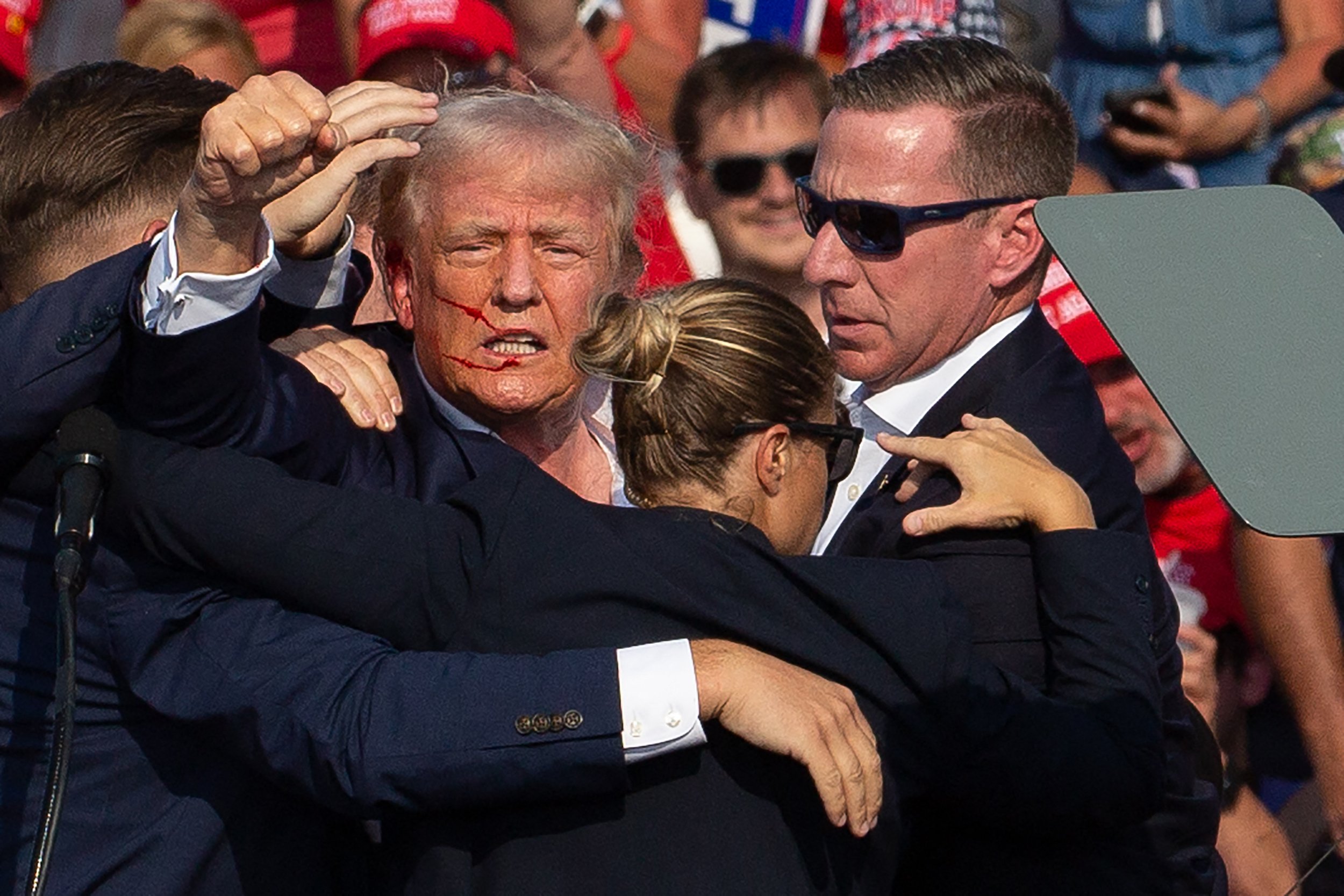 US Republican candidate Donald Trump is seen with blood on his face surrounded by secret service agents as he is taken off the stage at a campaign event at Butler Farm Show Inc. in Butler, Pennsylvania, on July 13, 2024. (Photo by Rebecca Droke/AFP via Getty Images)