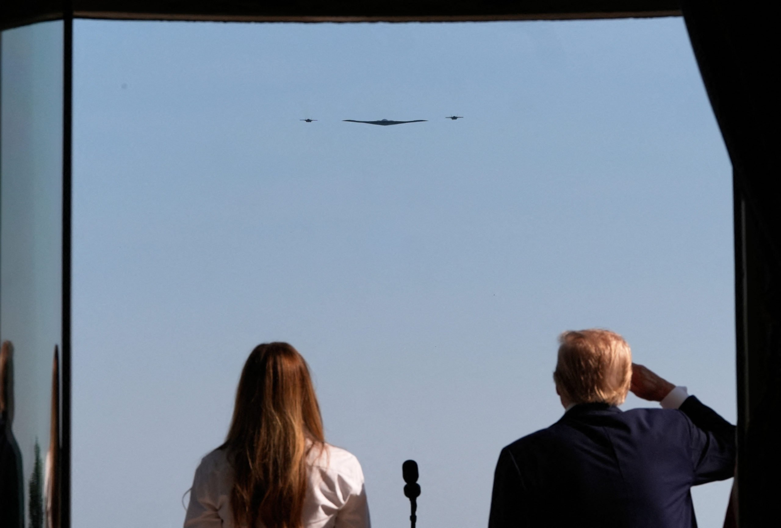 US president Donald Trump and First Lady Melania Trump observe as B-2 Spirit stealth bombers perform a military flyover from the Blue Room balcony of the White House during a Fourth of July celebration in Washington, DC on July 4, 2025. (Photo by Alex Brandon / POOL / AFP) (Photo by ALEX BRANDON/POOL/AFP via Getty Images)