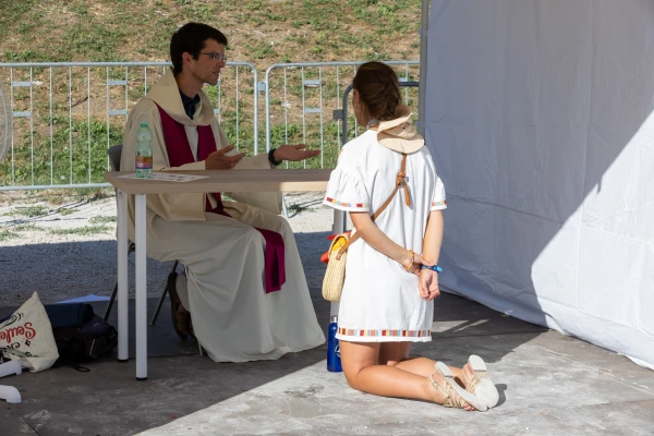 A penitent kneels before a priest during a reconciliation event at the Circus Maximus, Rome, Friday, Aug. 1, 2025. Credit: Daniel Ibáñez/CNA