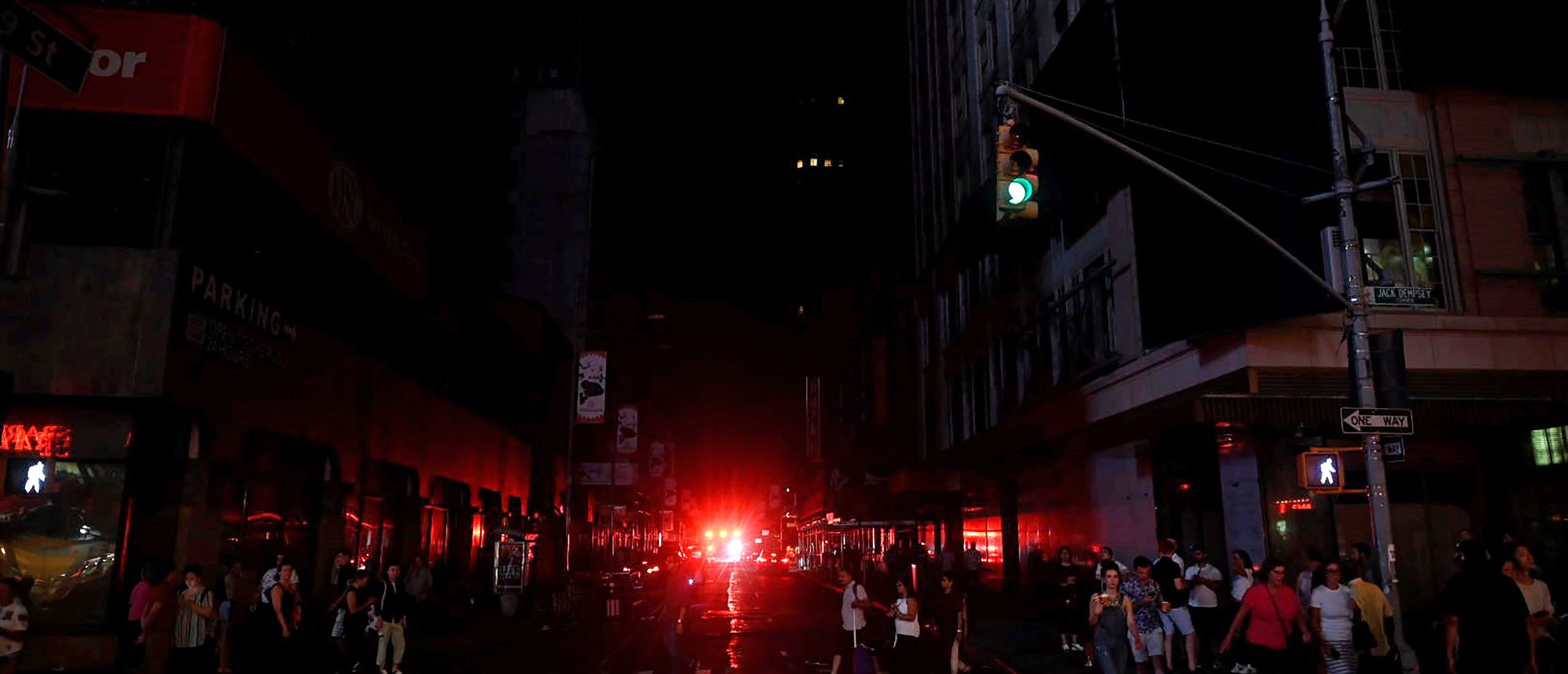 People walk down a street of Manhattan after a power outage hit the borough in New York City on July 13, 2019. (Photo by JOHANNES EISELE/AFP via Getty Images)