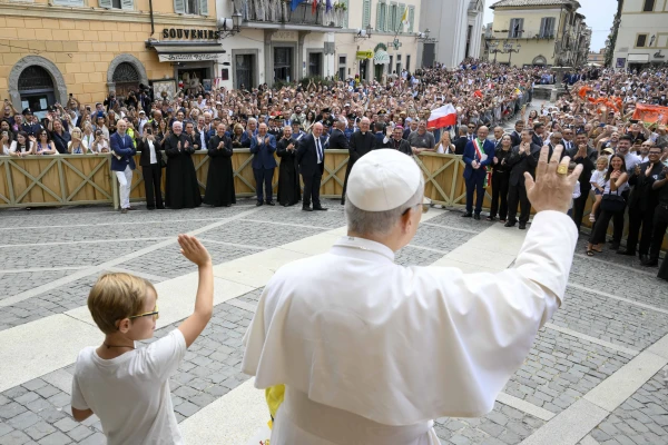 Pope Leo XIV waves with a young visitor during the Angelus outside the Church of St. Thomas of Villanova in Castel Gandolfo, Friday, Aug. 15, 2025. Credit: Vatican Media