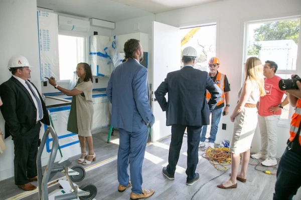 Community members tour a housing unit at
