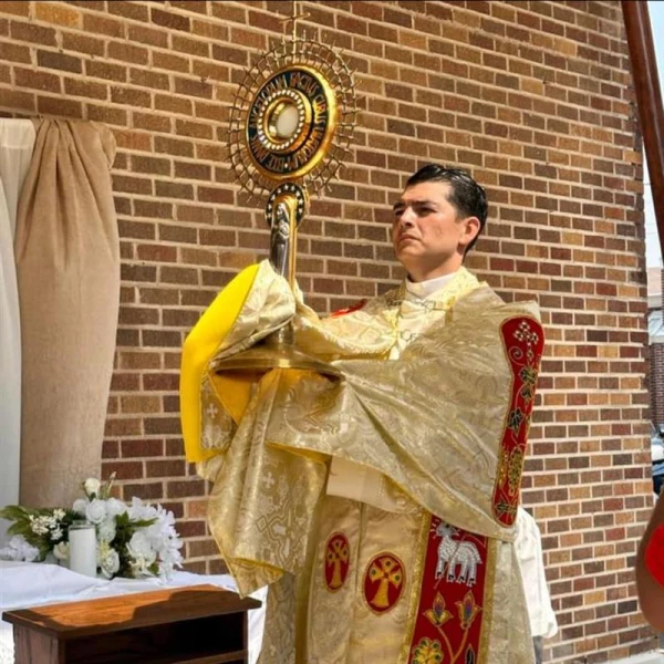 Father Alan Sanchez displays the Eucharist during adoration. Credit: Photo courtesy of Father Alan Sanchez