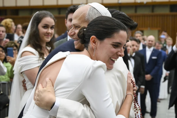 Pope Leo XIV hugs a newlywed couple at the general audience in the Paul VI Audience Hall, Vatican City, Wednesday, Aug. 27, 2025. Credit: Vatican Media