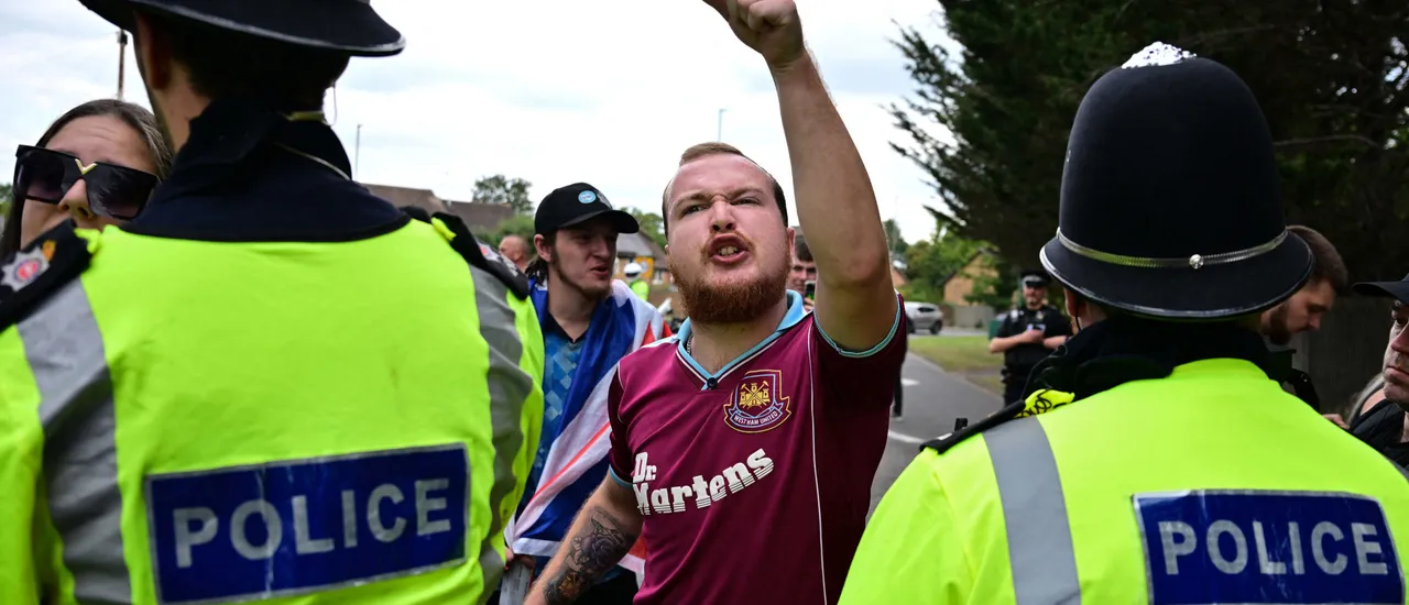 A demonstrator clashes with Police officers during an anti-immigration protest outside the Sheraton Four Points hotel, believed to be housing asylum seekers, in Horley, south of London, on August 23, 2025. A total of 111,084 people applied for asylum in the UK in the year to June 2025 -- the highest number ever. The figures come as Prime Minister Keir Starmer struggles to stem rising support for a hard-right party led by anti-immigrant firebrand Nigel Farage (Photo by BEN STANSALL/AFP via Getty Images)