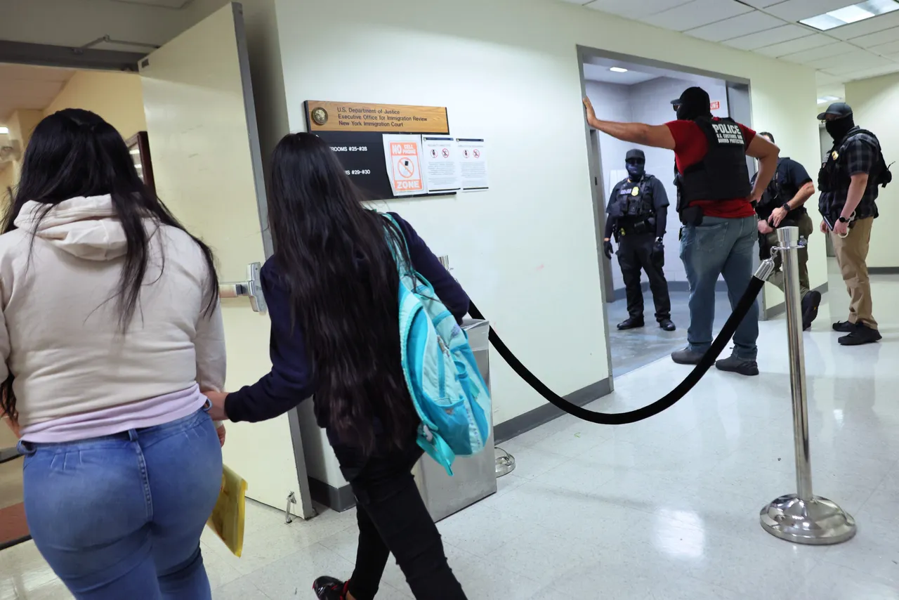 People walk into a court waiting room as federal agents patrol the halls of immigration court at the Jacob K. Javitz Federal Building. (Photo by Michael M. Santiago/Getty Images)