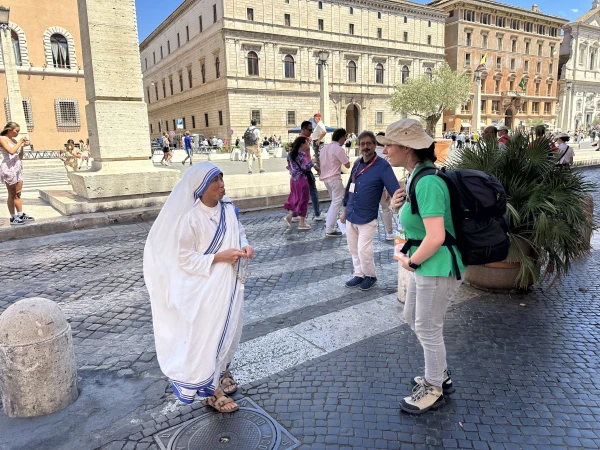 A Missionary of Charity speaks to young pilgrims on the Via della Conciliazione near Vatican City. Courtney Mares