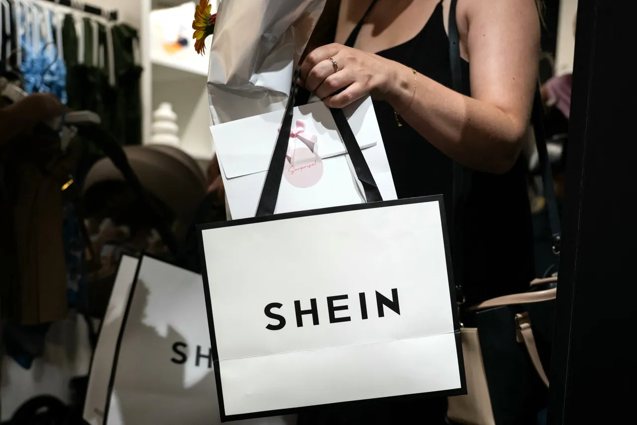 A customer holds her bags as she leaves a pop-up store of the Chinese-founded fast fashion brand Shein, in Dijon on June 26, 2025. (Photo by ARNAUD FINISTRE / AFP) (Photo by ARNAUD FINISTRE/AFP via Getty Images)