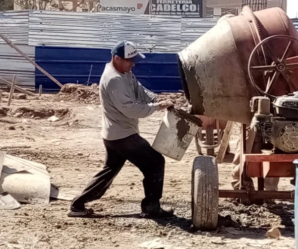 Father Javier Cajusol fills a bucket with cement for the construction of the church. Credit: Photo courtesy of Father Javier Cajusol