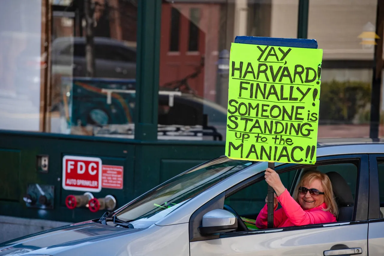 A demonstrator holds a sing in Harvard Square after a rally was held against President Donald Trump's attacks on Harvard University at Harvard University in Cambridge, Massachusetts on April 17, 2025. US President Donald Trump called Harvard a "joke" on April 16, 2025, and said it should lose its government research contracts after the prestigious university refused demands that it accept outside political supervision and ordered the freezing of $2.2 billion in federal funding to Harvard this week. The Department of Homeland Security (DHS) also canceled $2.7 million worth of research grants to Harvard on Wednesday and threatened the university's ability to enroll international students unless it turns over records on visa-holders' "illegal and violent activities." (Photo by JOSEPH PREZIOSO/AFP via Getty Images)