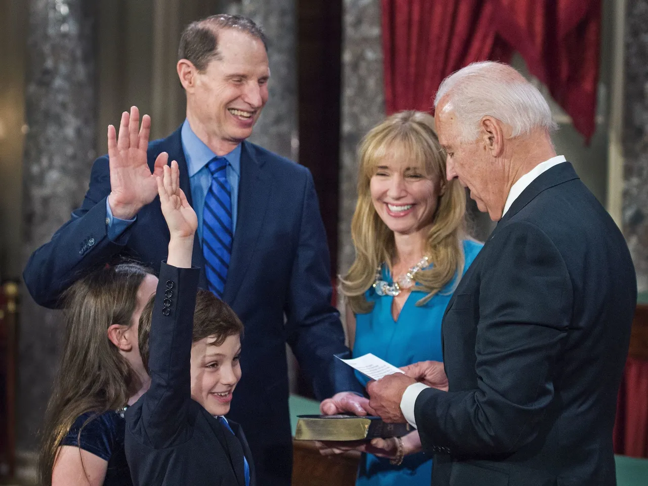 US Senator Ron Wyden(D-OR), is sworn in by US Vice-President Joe Biden as his wife Nancy holds the Bible with their children, during a reenacted swearing-in on January 3, 2017, in the Old Senate Chamber, on Capitol Hill, in Washington, DC. (Photo credit should read PAUL J. RICHARDS/AFP via Getty Images)