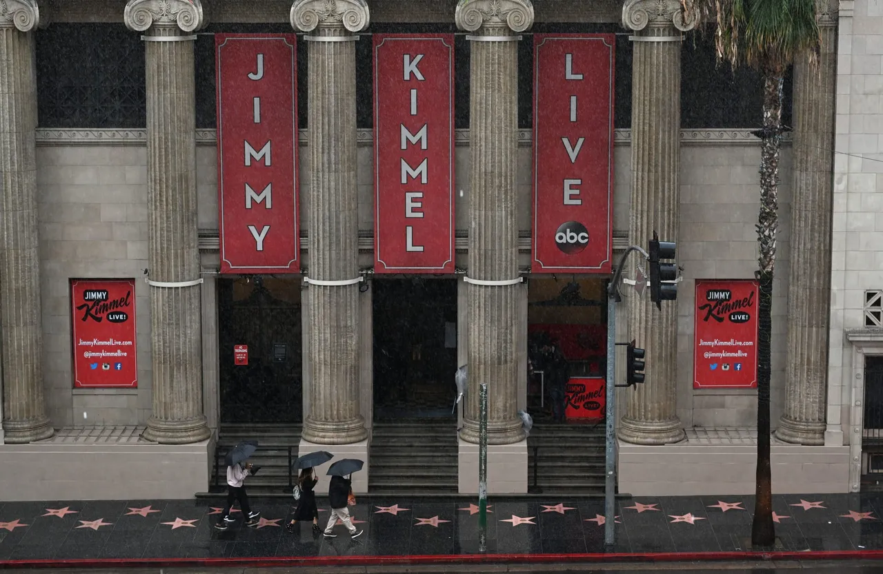 People walk past the Jimmy Kimmel Live studio as rain falls in Hollywood, California January 14, 2019. - A storm over Southern California delivered rain and snow, heightening the threat of mud and debris flows in areas scarred by recent wildfire. (ROBYN BECK/AFP via Getty Images)