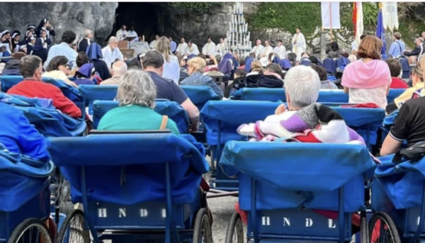 Pilgrims in the iconic blue carts attend Mass in the grotto of the Lourdes Shrine in France. Credit: Photo courtesy of Ana Melgar