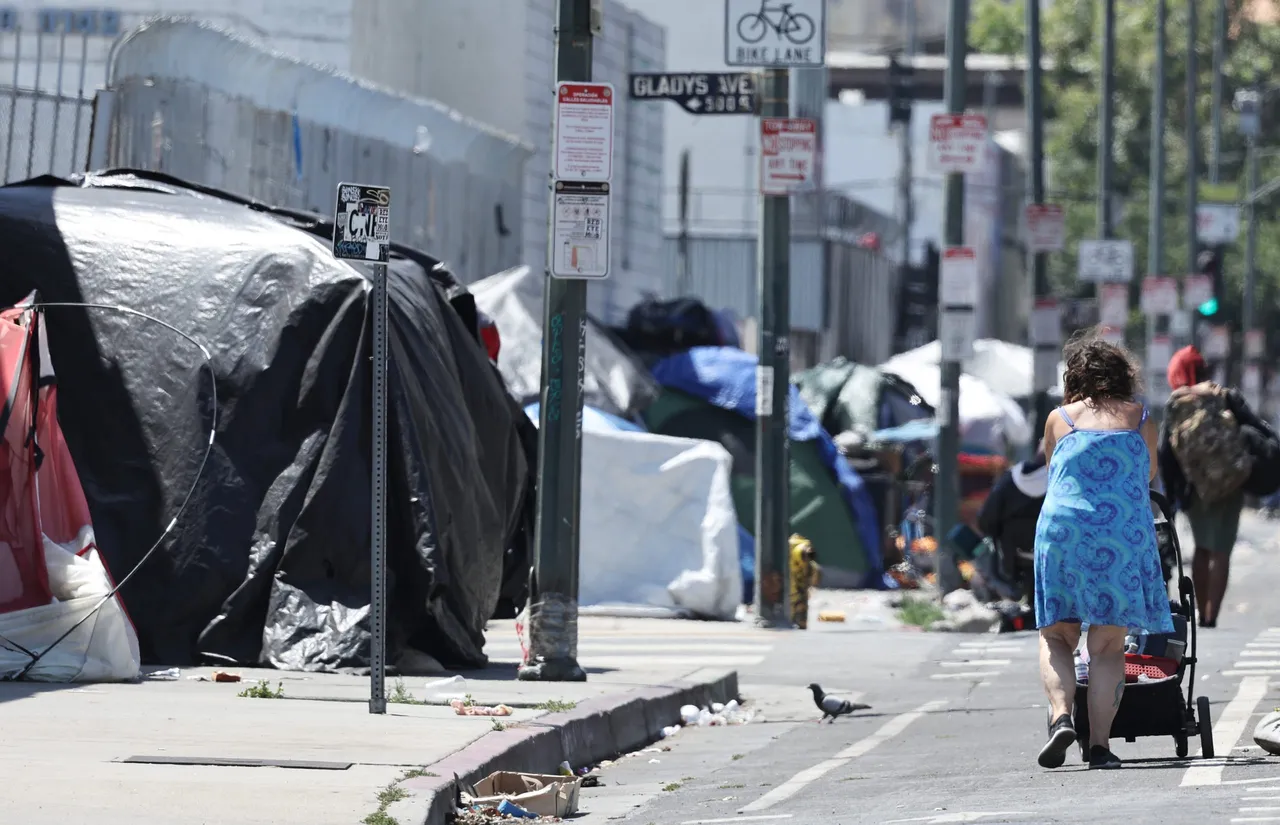 LOS ANGELES, CALIFORNIA - JUNE 28: A person walks near an encampment of unhoused people in the Skid Row community on June 28, 2024 in Los Angeles, California. The U.S. Supreme Court ruled today that cities can ban people, including those who are homeless, from camping and sleeping outdoors in public places, overturning lower court rulings. Skid Row is home to thousands of people who are either experiencing homelessness on the streets or living in shelters. (Photo by Mario Tama/Getty Images)