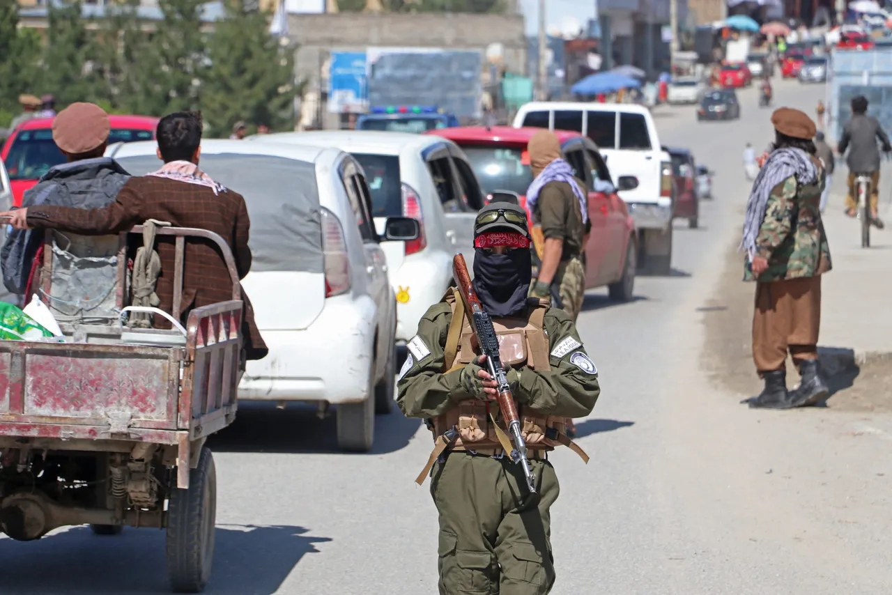 Taliban security personnel stand guard along a street to remove the window tint films from the cars of the commuters at a checkpoint in Fayzabad district of Badakhshan province on April 4, 2023. (Photo by OMER ABRAR/AFP via Getty Images)
