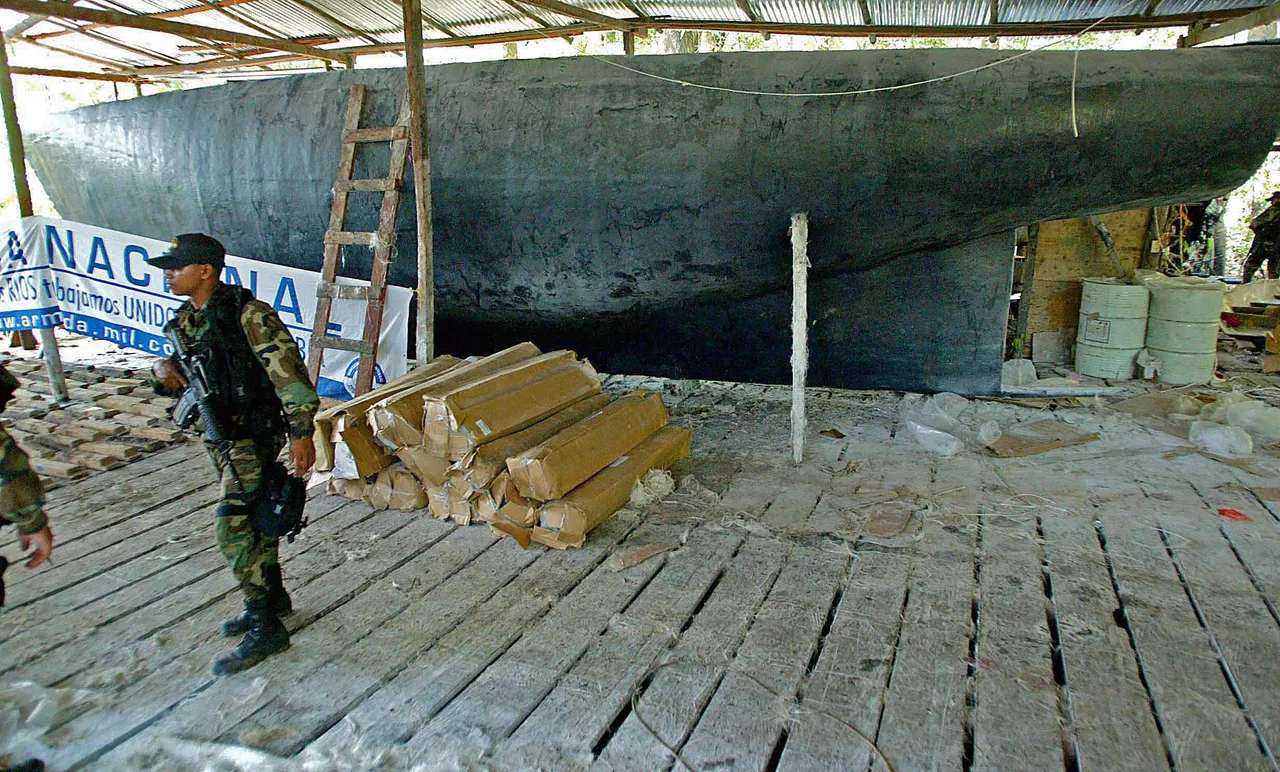 A Colombian Army soldier passes by an under construction submarine built by drug traffickers in Tumaco, on the Pacific coast, 26 March 2005 (MAURICIO DUENAS/AFP via Getty Images)