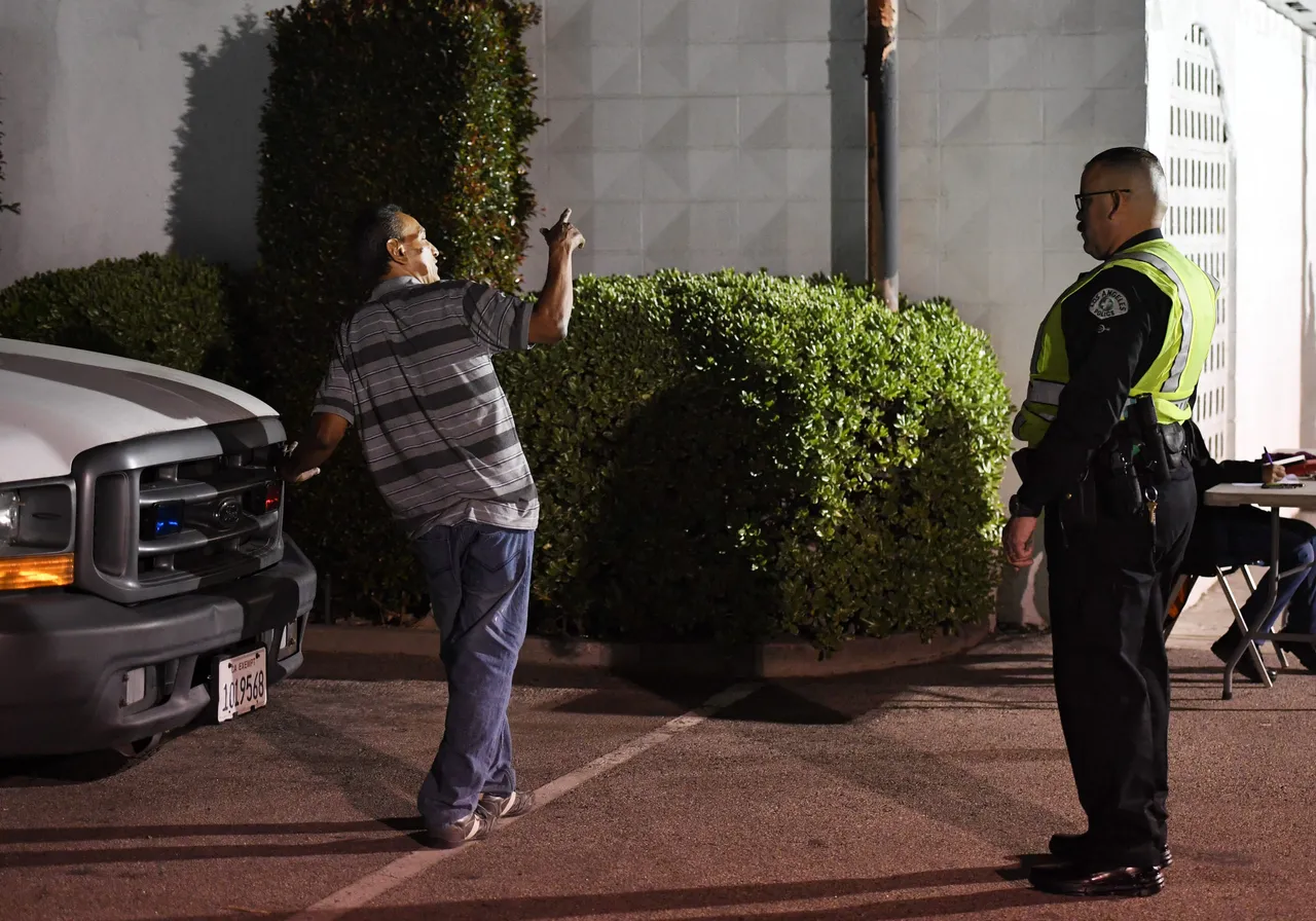 A man undergoes a sobriety test at a LAPD police DUI checkpoint in Reseda, Los Angeles, California on April 13, 2018. (Photo by MARK RALSTON/AFP via Getty Images)