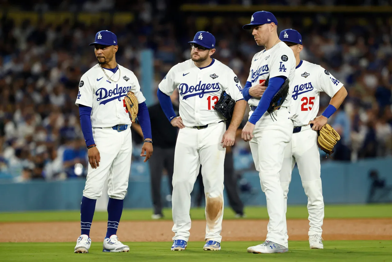 LOS ANGELES, CALIFORNIA - OCTOBER 28: Mookie Betts #50, Max Muncy #13, Freddie Freeman #5 and Tommy Edman #25 of the Los Angeles Dodgers look on during a pitching change as Blake Treinen #49 (not pictured) enters the game as they take on the Toronto Blue Jays in game four of the 2025 World Series at Dodger Stadium on October 28, 2025 in Los Angeles, California. Toronto won 6-2. (Photo by Ronald Martinez/Getty Images)