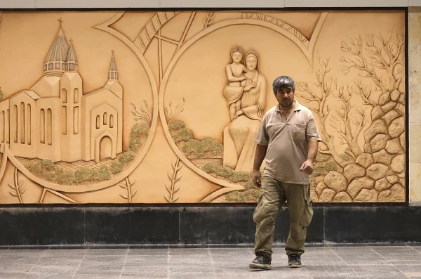 An Iranian worker walks in front of a relief sculpture of the Virgin Mary at the newly-opened Maryam Moghaddas (Virgin Mary) metro station near the Sarkis Cathedral of the Armenians in Tehran on Oct. 18, 2025. Credit: ATTA KENARE/AFP via Getty Images