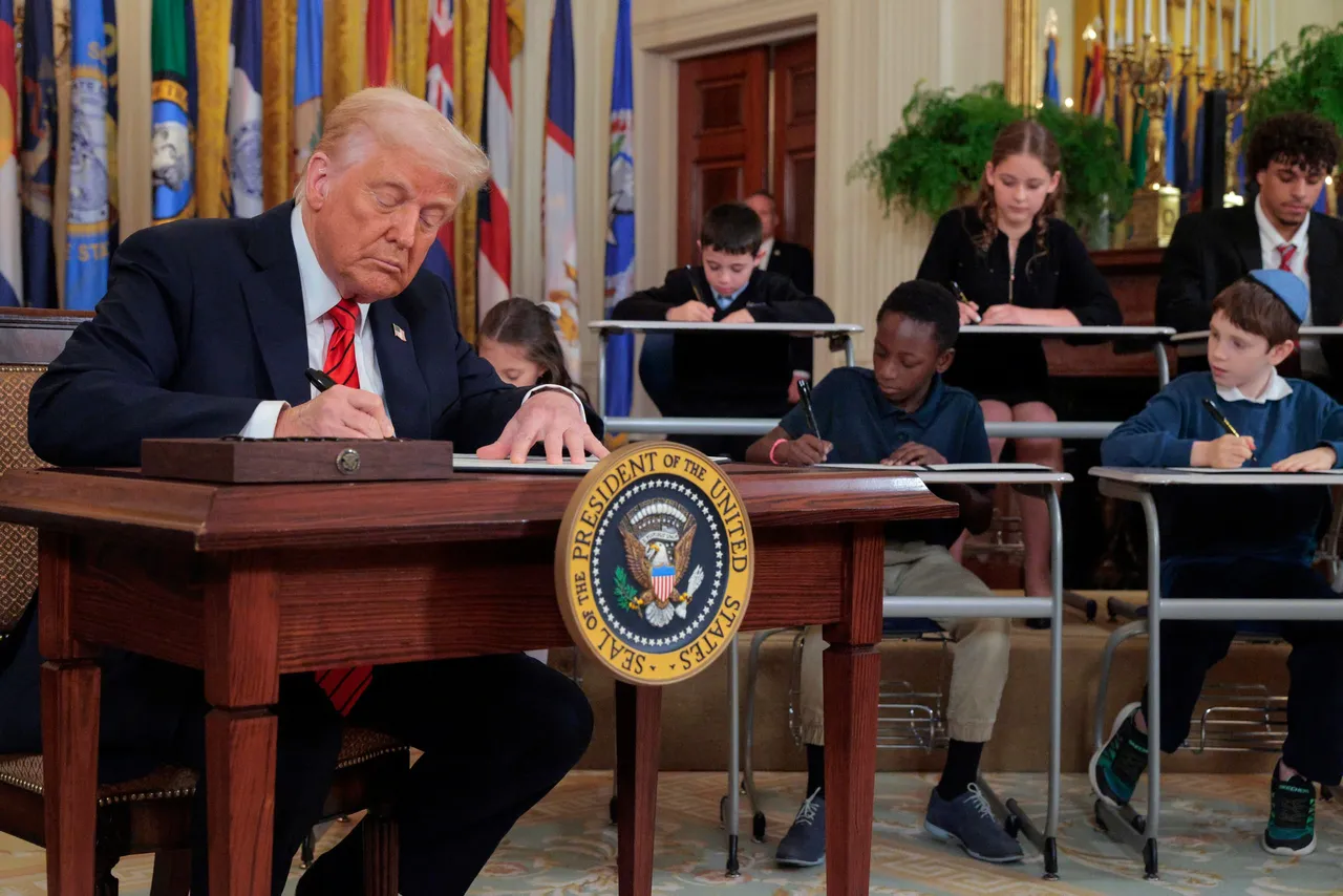 U.S. President Donald Trump signs an executive order to reduce the size and scope of the Education Department alongside school children signing their own versions, during a ceremony in the East Room of the White House on March 20, 2025 in Washington, DC.