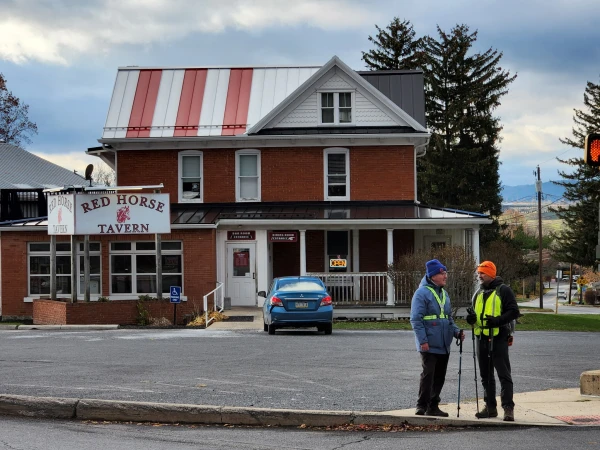Father Gary Graf speaks to a fellow American at Red Horse Tavern in Pleasant Gap, Pennsylvania, Tuesday, Nov. 11, 2025. Credit: Photo courtesy of Father Gary Graf