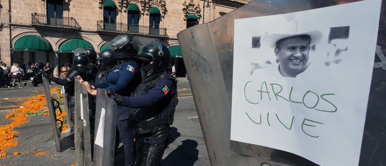 Police officers stand guard as protesters demonstrate against the assassination of Uruapan's mayor at the Government Palace in Morelia, Michoacan state, Mexico, on November 3, 2025.