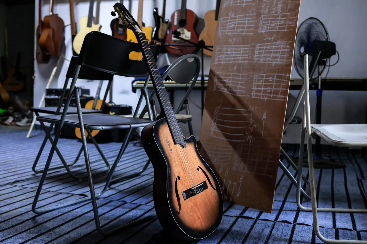 A general view of a guitar made by Clovis Tchoufack (not seen) and displayed in his workshop, in Douala on August 18, 2025. Clovis Tchoufack is a former carpenter with 7 years of training. During an argument, his girlfriend broke his guitar and he was unable to afford another one. He took his guitar back to the carpentry shop and tried to reproduce another one from the broken one. He learned how to build guitars by watching videos online. It took him a year, which is how he decided to make it his full-time job. Today, he wants to hone his skills with leading manufacturers so he can become a major guitar maker in Africa. (Photo by Daniel Beloumou Olomo / AFP) (Photo by DANIEL BELOUMOU OLOMO/AFP via Getty Images)