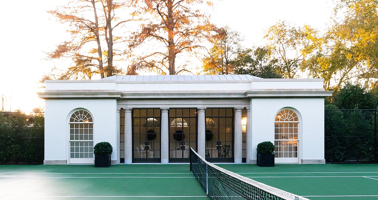 Elegant tennis clubhouse with trees in background