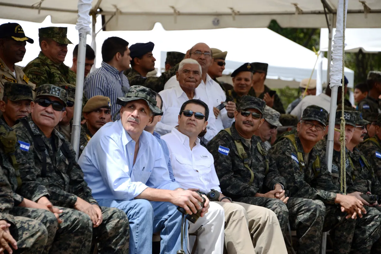 Honduran President Juan Orlando Hernandez (C) and Tegucigalpa's Mayor Nasry Tito Asfura (C-L) attend the celebration of the 51st anniversary of the second airborne artillery battalion in Tamara, 20 km north of Tegucigalpa, on August 22, 2015. (Photo credit should read ORLANDO SIERRA/AFP via Getty Images)