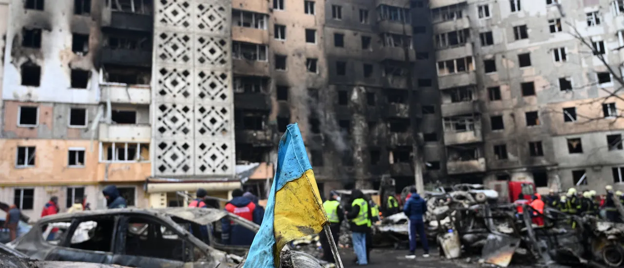 A Ukrainian flag is seen attached to a burned car at the site of a heavily damaged residential building following Russian air strike in the city of Ternopil, on November 19, 2025, amid the Russian invasion of Ukraine.