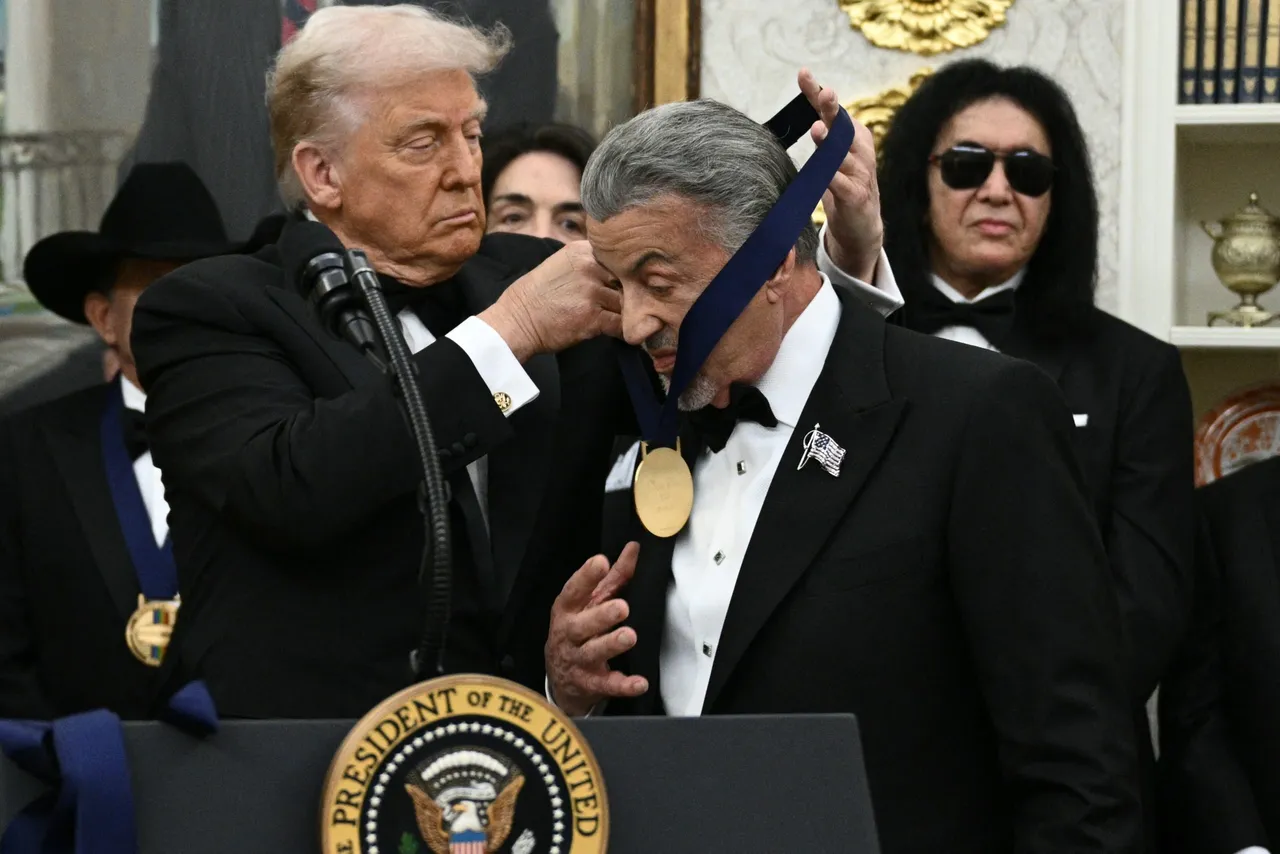 Kennedy Centre Honours recipient actor Sylvester Stallone receives a medal from US President Donald Trump during the Kennedy Centre Honours medal presentation ahead of tomorrow's ceremony, in the Oval Office of the White House in Washington, DC, December 6, 2025. (Photo by Brendan SMIALOWSKI / AFP via Getty Images)